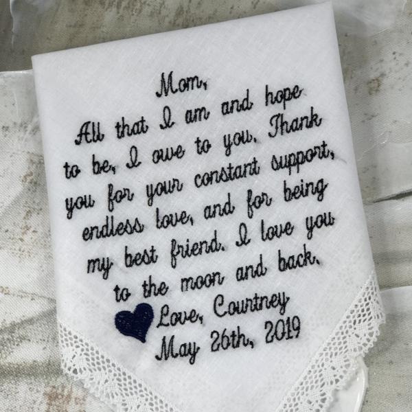 White handkerchief with lace edging. It has words on it that says: Mom, All that I am and hope to be, I owe to you. Thank you for your constant support, endless love, and for being my best friend. I love you to the moon and back. Love, Courtney May 26, 2019